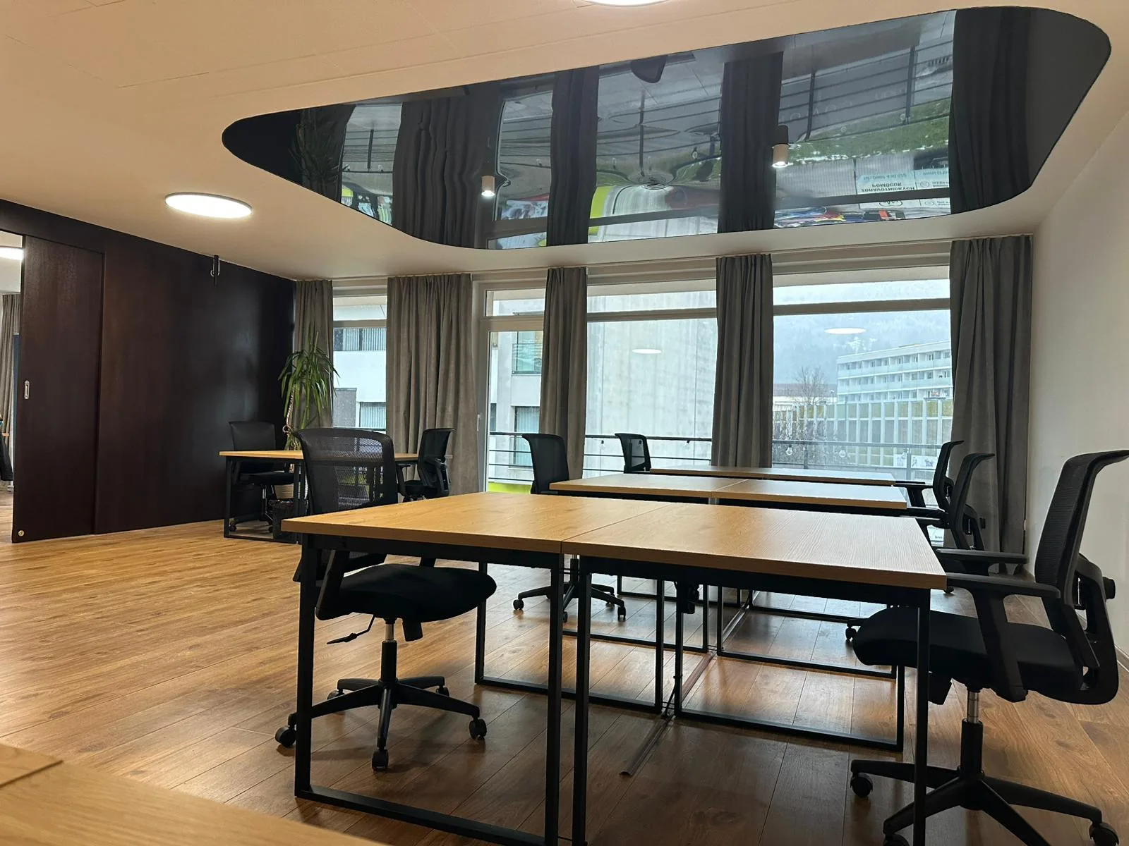 Inside the LeanUP coworking space in Ružomberok — desks and mountain view