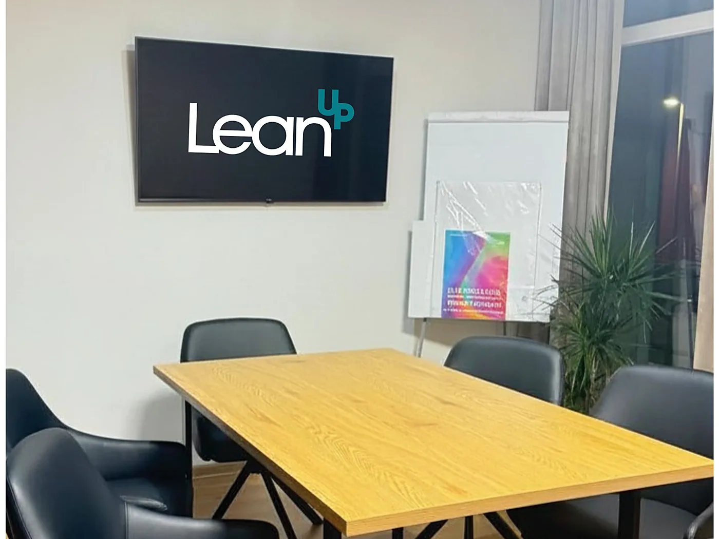 Meeting room with table for six, presentation screen and flipchart